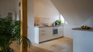 A modern kitchen with a wooden countertop, a built-in oven, and a window providing natural light. - Moderne, Helle Wohnung (Heidelberg)