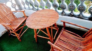 Ein Balkon mit Korbstühlen und einem kleinen runden Tisch.