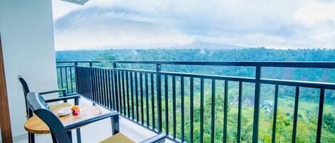 A balcony with a view of a lush green landscape.