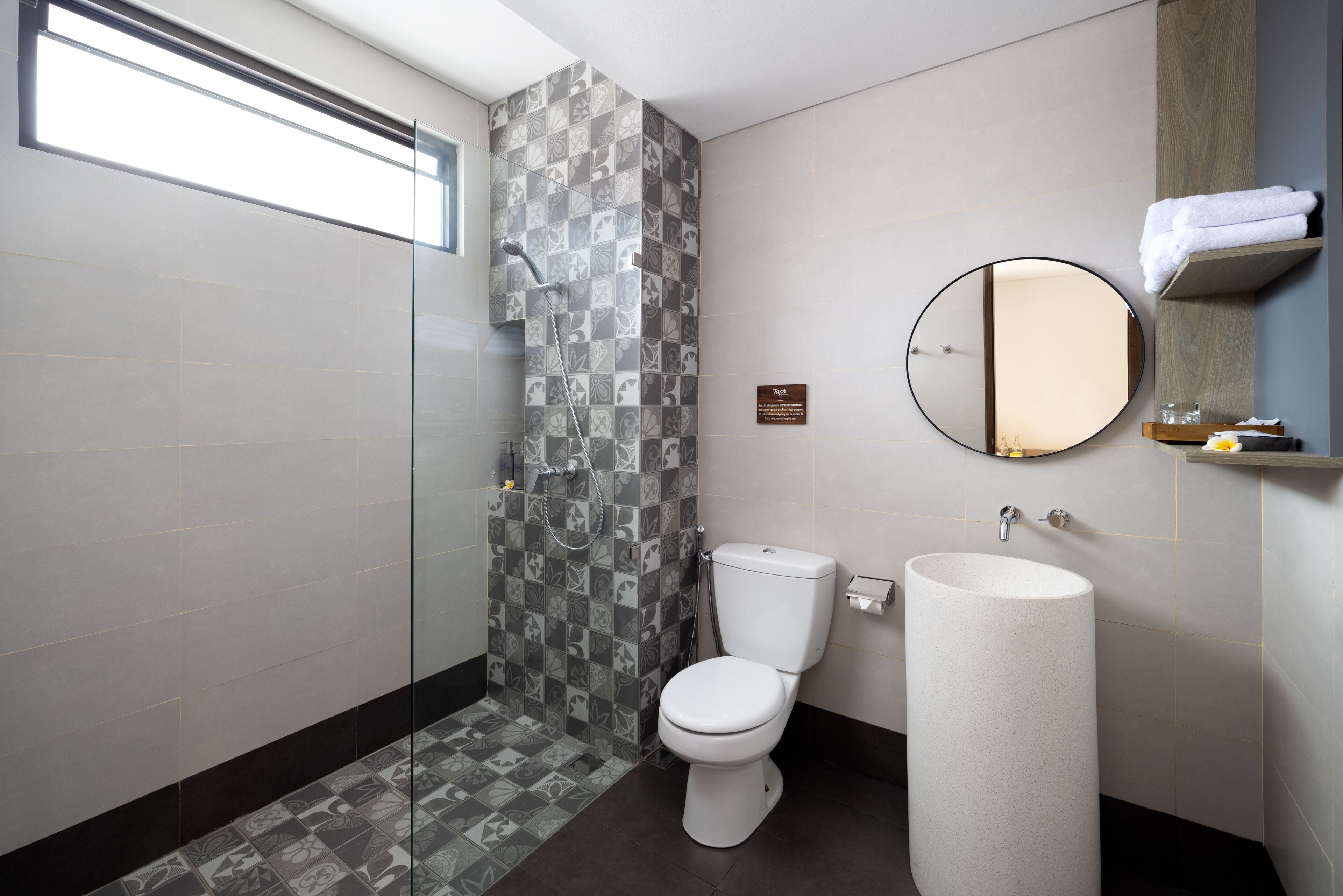 A modern bathroom with a shower, toilet, and sink.