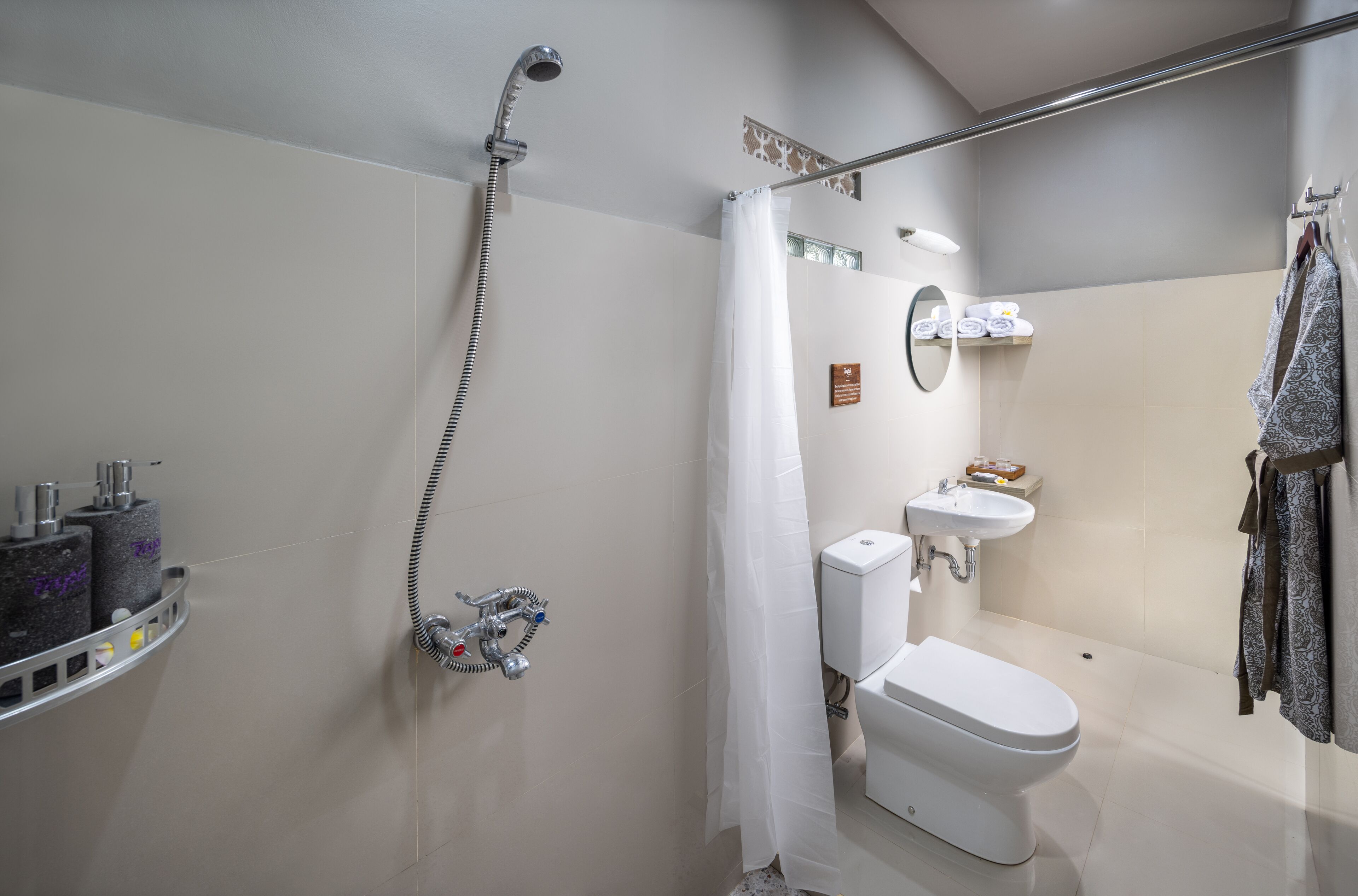 Ein modernes Badezimmer mit Dusche, Toilette, Waschbecken und Handtuchhalter.