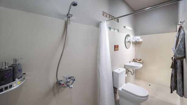 A modern bathroom with a shower, toilet, sink, and towel rack. - Tapa Agung View (Rendang)