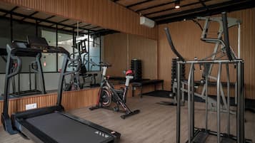 Academia com esteiras, bicicletas ergométricas e aparelhos de musculação.