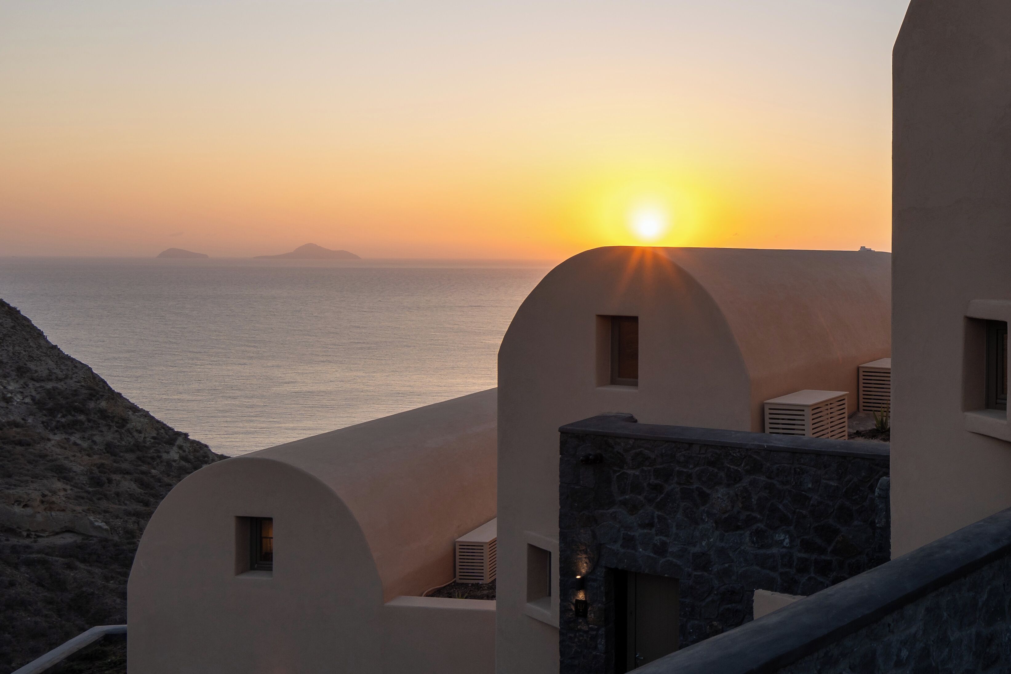 Ein Küstenhaus mit Blick auf das Meer bei Sonnenuntergang.