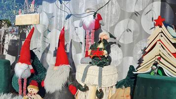 Festlig udstilling med julepynt, blandt andet nissefigurer og et lille juletræ.