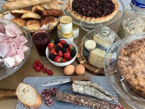 A variety of food items including pastries, cheese, and fruits on a table. - Les Cailloux Dorés (Massillargues-Attuech)