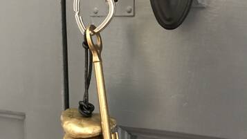Un llavero de bronce con un diseño único, colgando de una puerta gris.