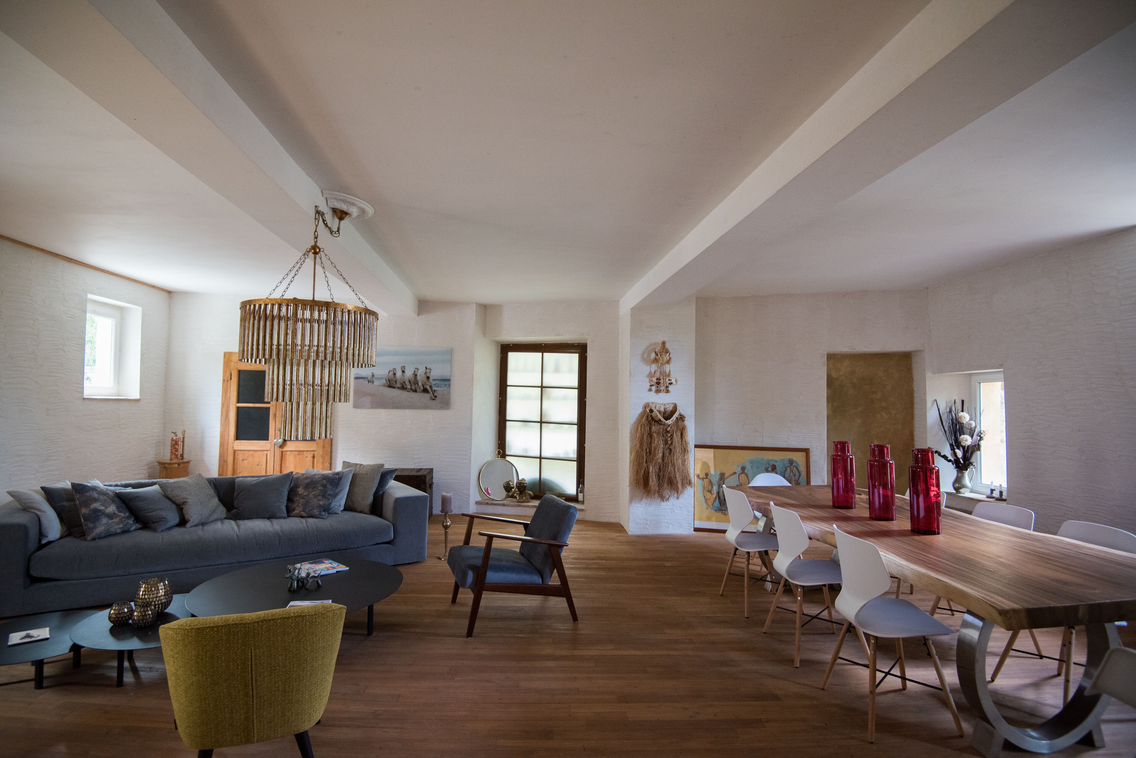 Un vaste espace de vie comprenant un canapé, une table basse et une table à manger avec des chaises.