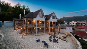 A stone building with a stone patio, outdoor seating, and a Christmas tree. - Dandy Villas Karpenisi-Lux Chalet (Karpenisi)
