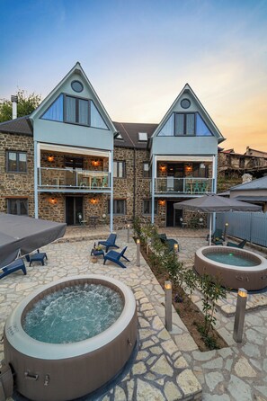 A stone building with a stone patio, outdoor seating, and hot tubs. - Dandy Villas Karpenisi-Lux Chalet (Karpenisi)