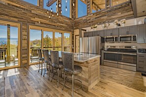 A spacious kitchen with modern appliances, a large island, and a view of the outdoors.