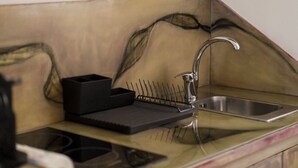 Une cuisine équipée d’un évier, d’une horloge et d’un placard.