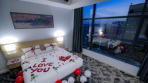 A hotel room with a large bed, a city view, and a decorative wall piece. - Laten Suites Al Salim Plaza (Jeddah)