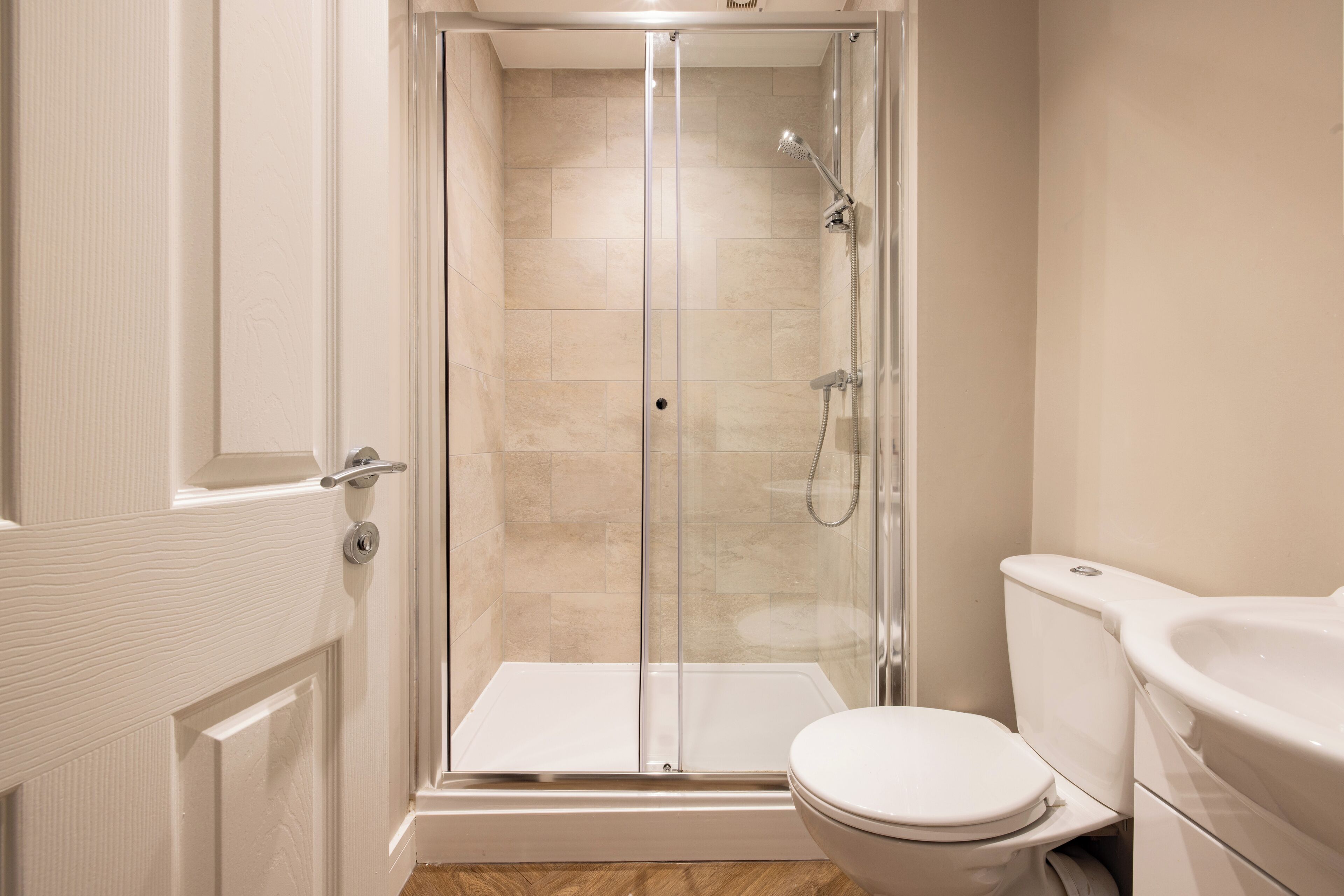 Une salle de bain moderne avec une douche à parois de verre, des toilettes blanches et un lavabo.
