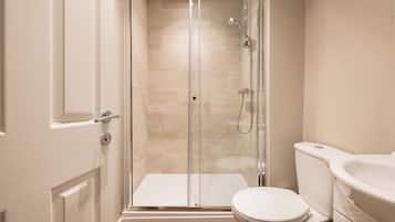 Une salle de bain moderne avec une douche à parois de verre, des toilettes blanches et un lavabo.