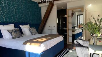 A modern bedroom with a large bed, a desk, and a chair.