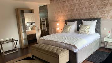 Un dormitorio con una cama grande, un banco de madera, una mesita de noche y un espejo.