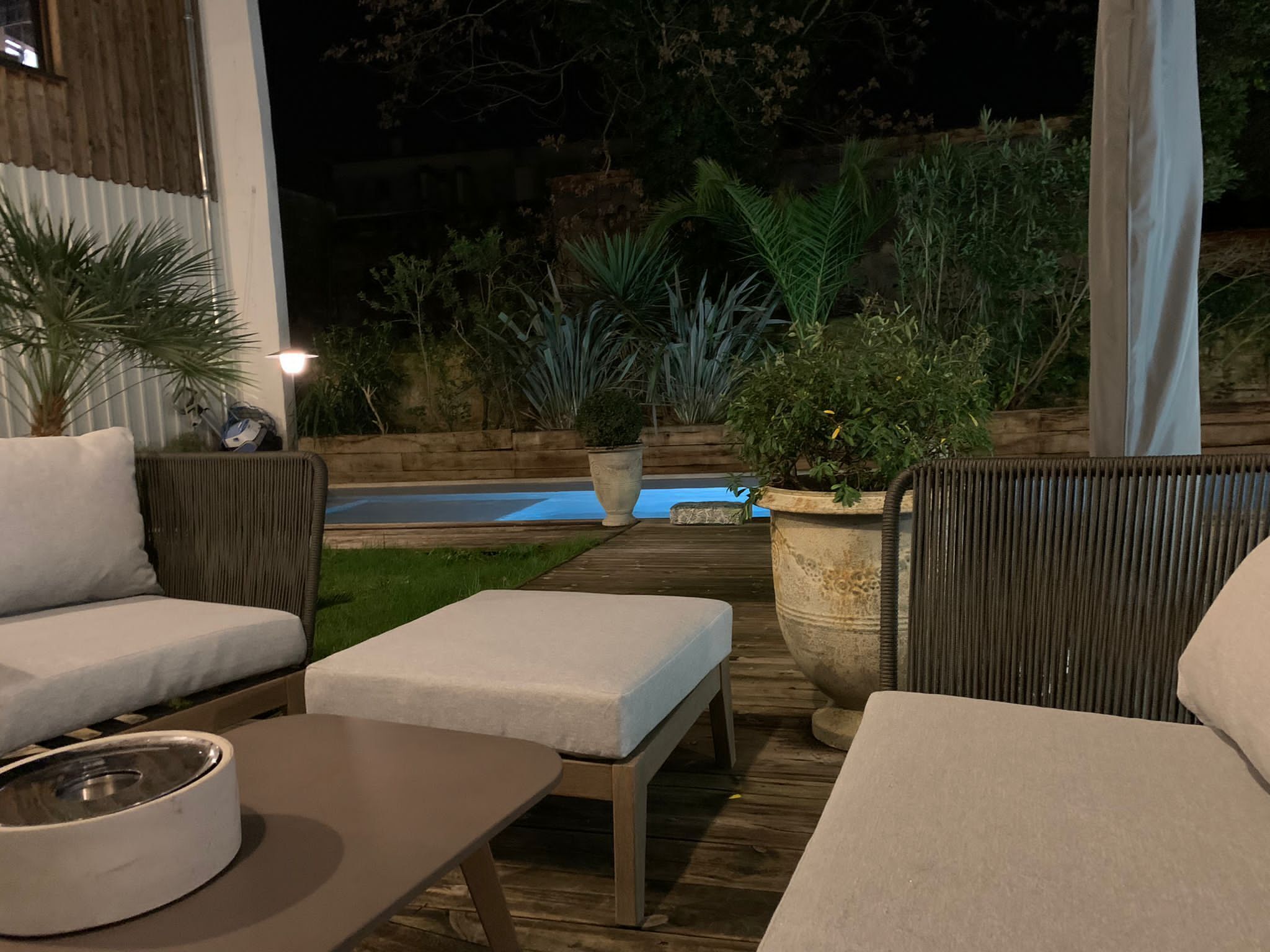 Eine Außenpatio-Terrasse mit Pool, Holzdeck und Sitzgelegenheiten.