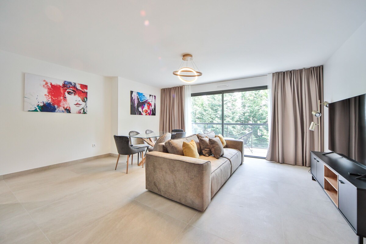 A modern living room with a sofa, a TV, and artwork on the walls.