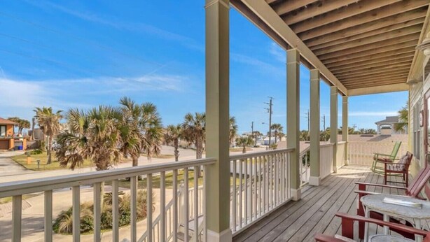A covered porch with a view of palm trees and a street. - Beachfront Retreat | 3-Story Home | Walk to Vilano Beach | Near Nights of Lights (St. Augustine)