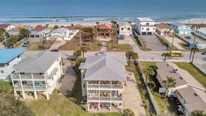 A coastal residential area with multiple two-story houses, a beach in the background, and a clear sky. - Beachfront Retreat | 3-Story Home | Walk to Vilano Beach | Near Nights of Lights (St. Augustine)