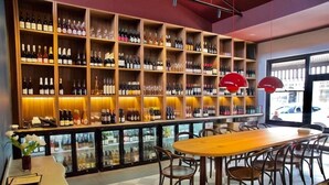 A bar area with shelves of bottles, a wooden table, and chairs. - Fabulous 2BR close to the heart of East Fremantle - walk to the river (East Fremantle)