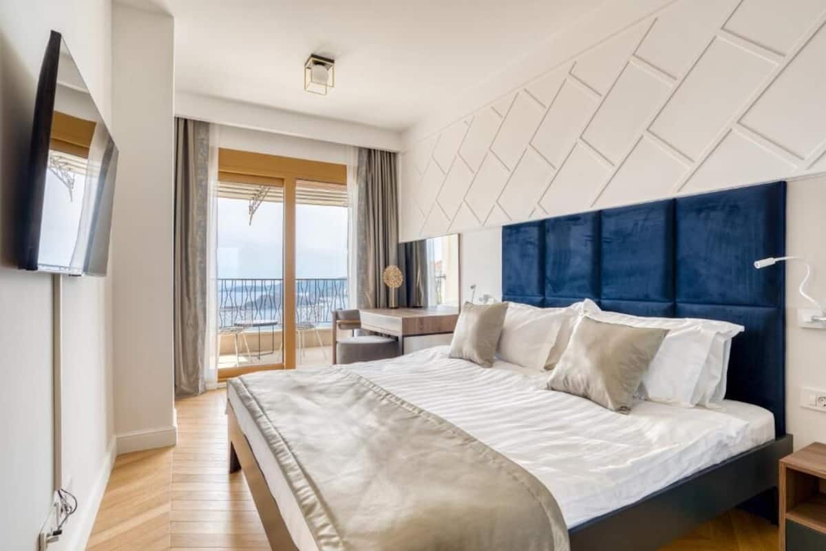 Una habitación de hotel moderna con una cama grande, un escritorio y vista al mar.