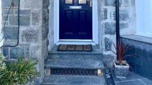 A stone building with a dark blue door and a sign reading "Albion House." - Remarkable 1-bed Seaview Beach Apartment Barmouth (Barmouth)