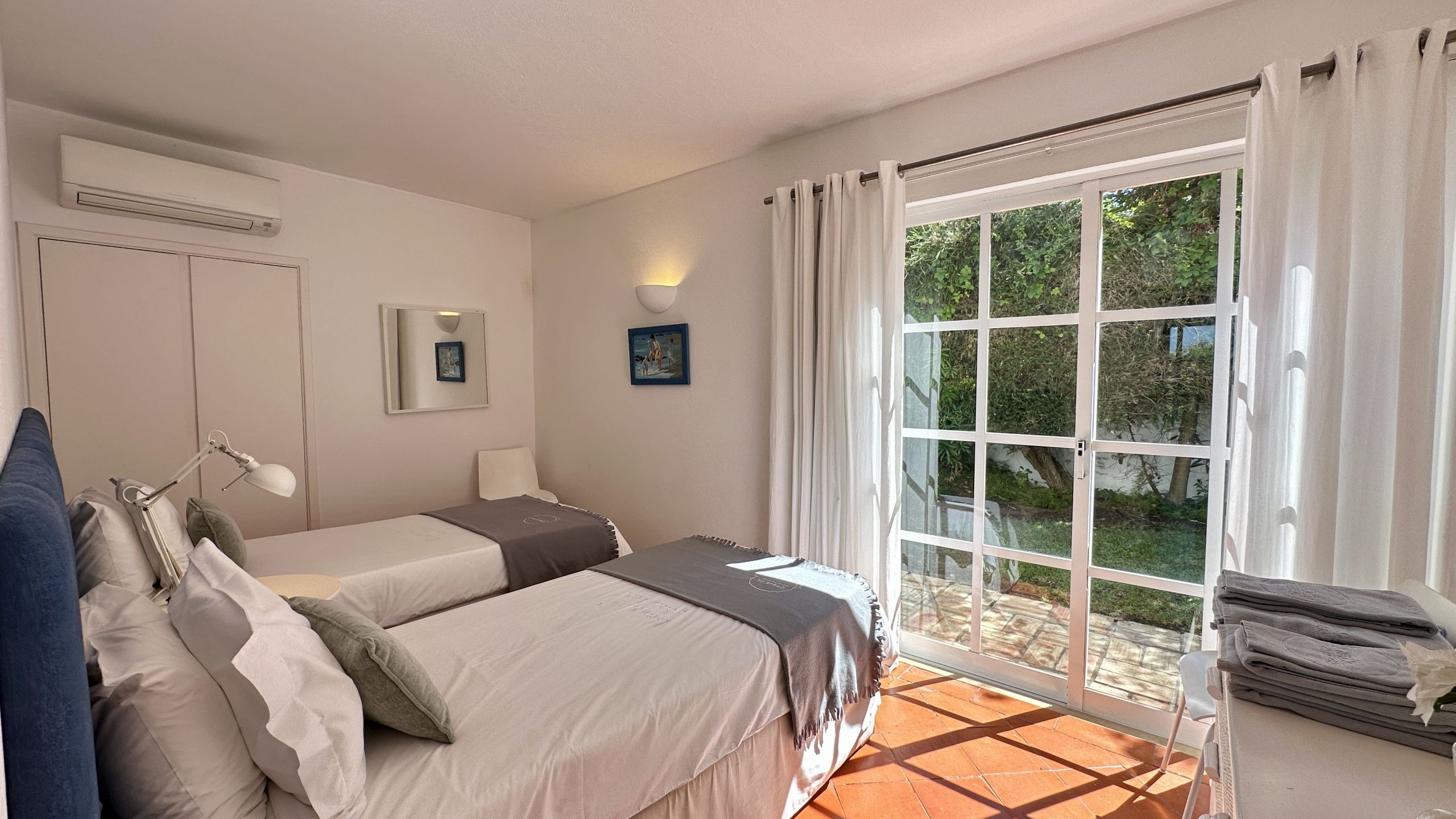 Una camera da letto con due letti, una finestra e vista su del verde.