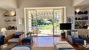 Un salón comedor amplio con un gran ventanal corredero que da a un patio exterior.