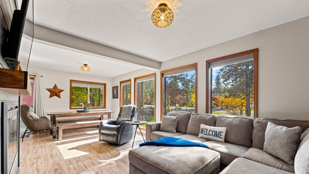 A spacious living room with a large sectional sofa, a dining table, and a star decoration on the wall.