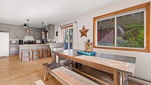 A modern kitchen with wooden countertops, a dining area with a bench, and a large window with a star decoration.