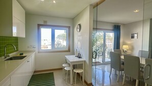 Une cuisine compacte avec une fenêtre, un coin repas avec des chaises et une petite table.