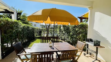 Enjoy al fresco dining on this serene patio, complete with a table for four, a grill, and comfortable seating.