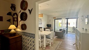 A dining area with a table and chairs, a TV, and a balcony with a view. - Medronheira by Check-in Portugal (Albufeira)