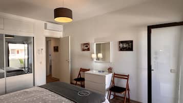 1 dormitorio y tabla de planchar con plancha
