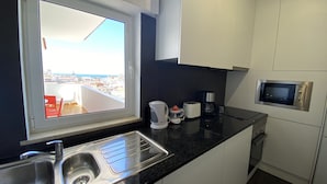 A modern kitchen with a large window, a built-in microwave, and a coffee maker.