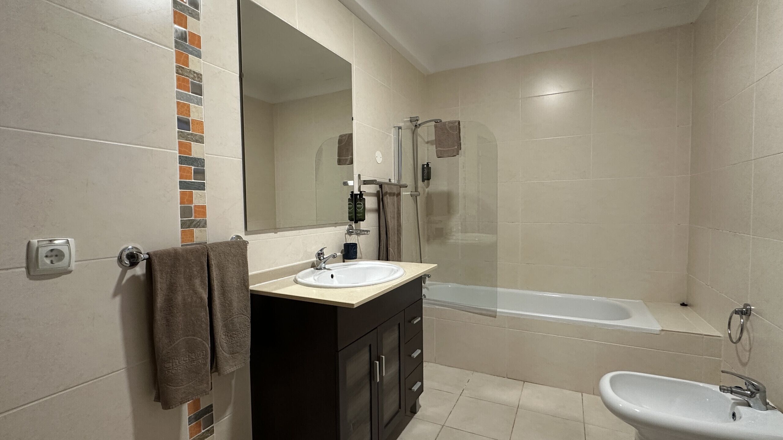 A bathroom with a bathtub, a sink, and a shower area.