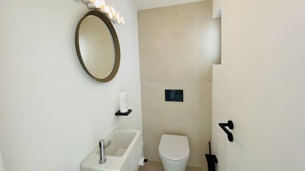 A bathroom with a sink, toilet, and a mirror. - Moderna by Check-in Portugal (Quarteira)