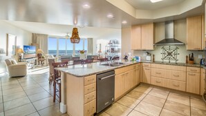A spacious kitchen with a large island, wooden cabinets, and a dishwasher. - Caribe D814 (Orange Beach)