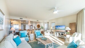 A spacious living area with a sofa, armchairs, a coffee table, a TV, and a ceiling fan. - Caribe D814 (Orange Beach)