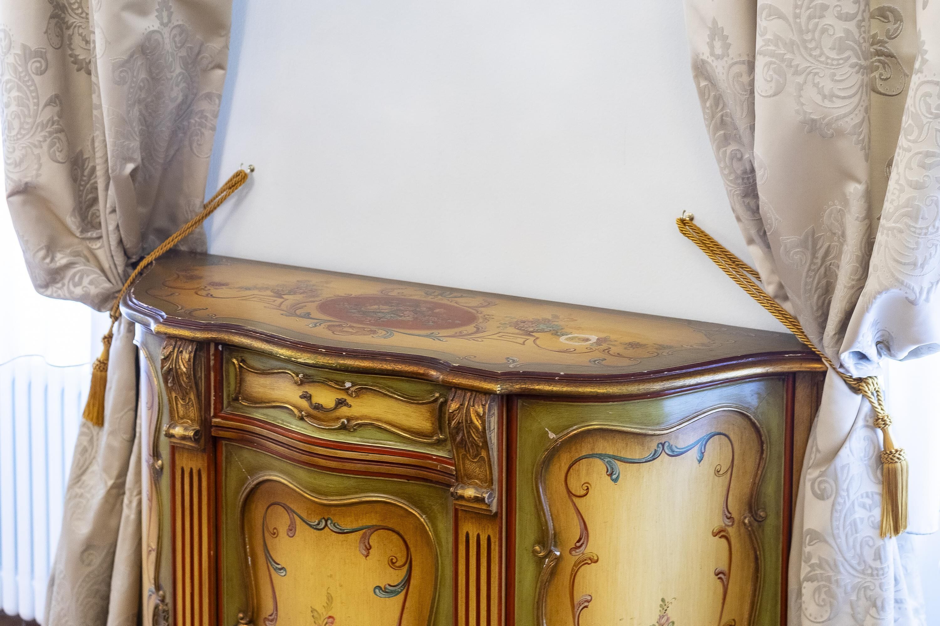 A vintage-style wooden cabinet with ornate carvings and a decorative top.
