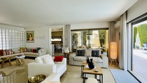 A spacious living area with a white sofa set, a coffee table, and a dining area visible through an open door. - Praia by Check-in Portugal (Albufeira)
