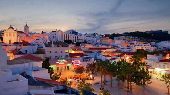 A coastal town at dusk with white buildings, a church, and a restaurant named 'Rock Cafe.'
