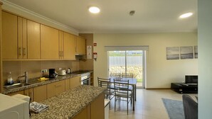 Una cocina compacta con encimeras de granito, armarios de madera y un comedor con mesa y sillas.