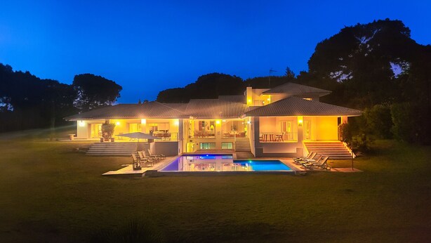 A two-story house with a swimming pool, outdoor seating, and a well-lit patio area. - Azaleas by Check-in Portugal (Vilamoura)