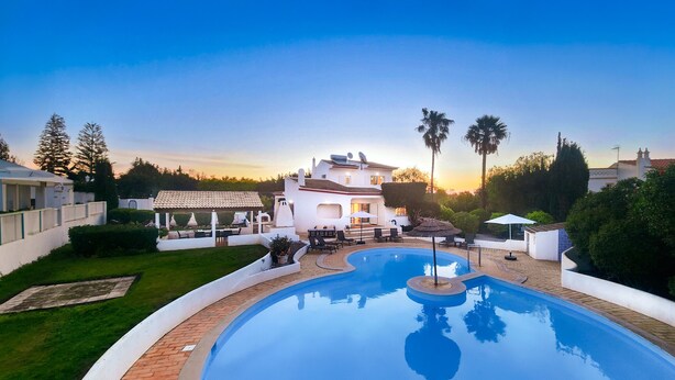 A large, modern house with a swimming pool, surrounded by lush greenery and palm trees. - Nicola by Check-in Portugal (Albufeira)