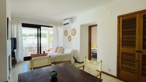 Relax in this serene space with a comfortable bed, seating area, and sliding glass door leading to an outdoor space.