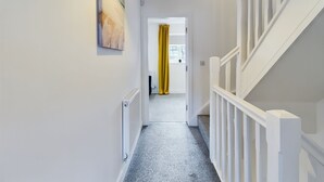 A hallway with a radiator, a white railing, and a yellow curtain. - Cosy and Luxurious House for 10 Guests in Darwen (Darwen)