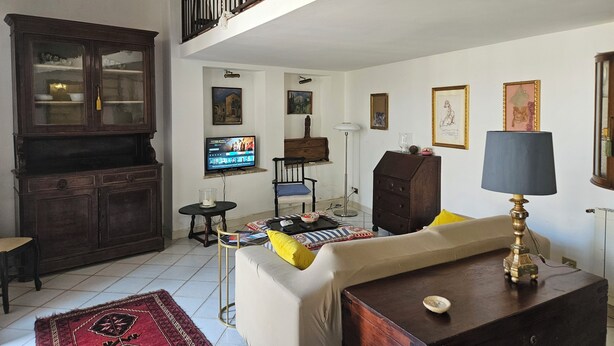 A living room with a sofa, a television, a cabinet, and a lamp.